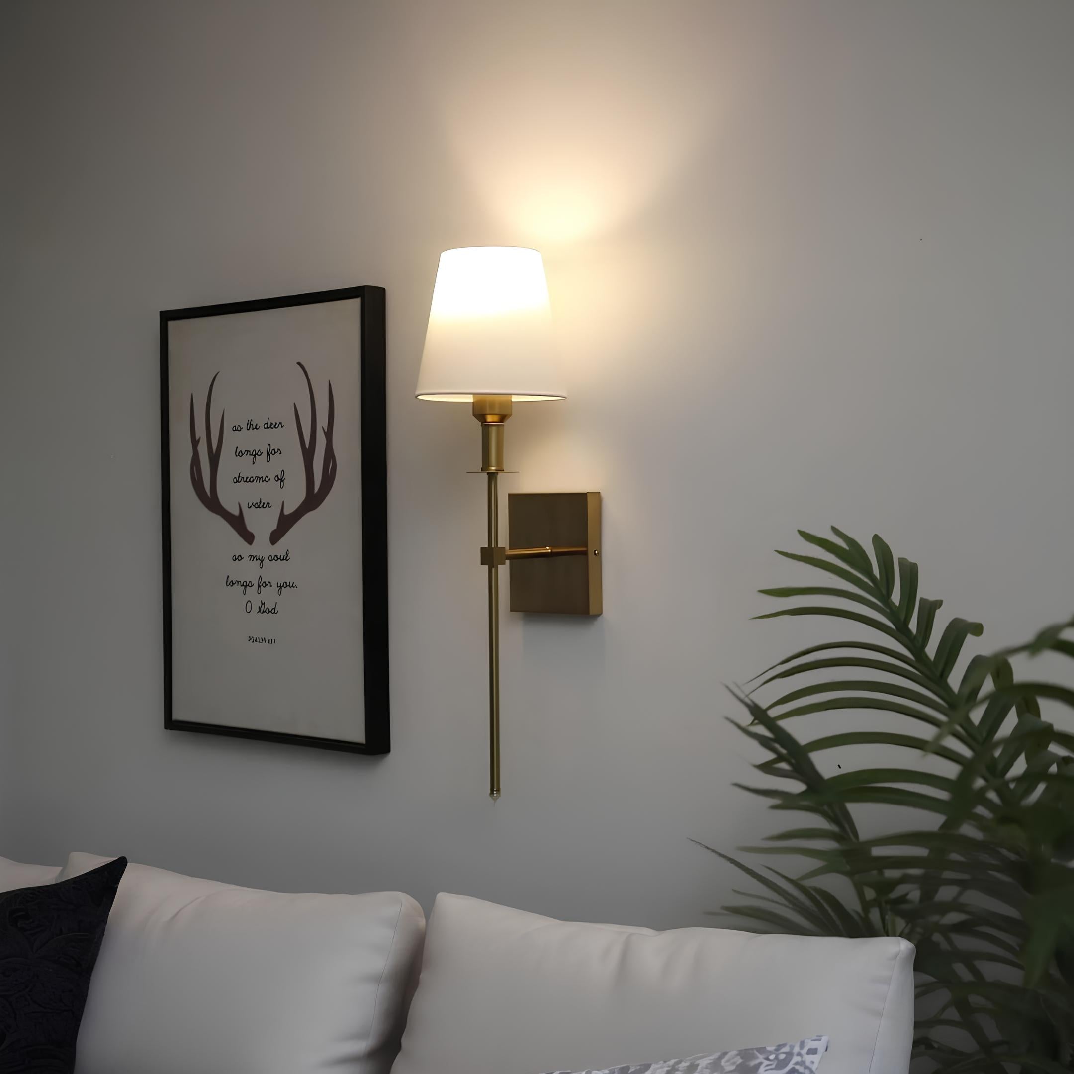 De Aurelia Wall Light straalt klassieke elegantie uit met zijn gouden afwerking en verfijnde lampenkap, perfect voor het verlichten van je woonkamer of slaapkamer.