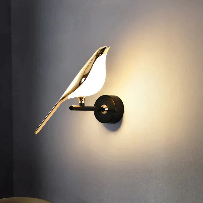 Auroria wandlamp met een elegant vogelontwerp in goud, gemonteerd op een zwarte basis, creëert een artistieke en sfeervolle verlichting voor moderne interieurs.