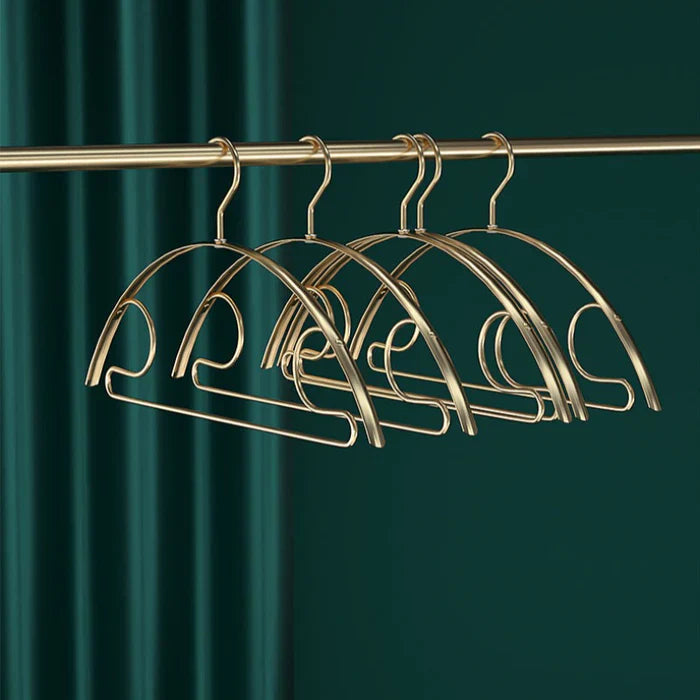 Stijlvolle gouden kledinghangers met een elegant ontwerp, perfect voor het ophangen van kleding in een kast. De hangers zijn ontworpen met een verfijnde boog en een praktische onderkant voor extra kledingaccessoires.